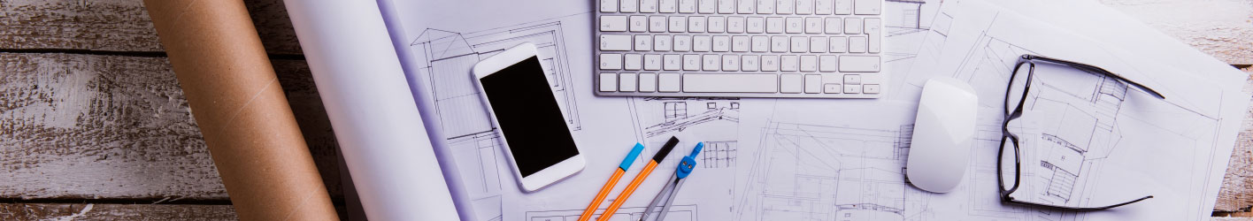 Picture of blueprints, a phone, glasses, keyboard, pens, and a compas