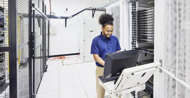 Data center employee uses computer on portable cart