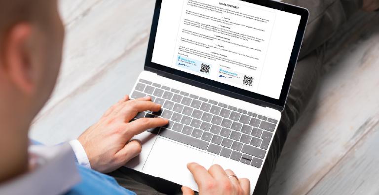 Laptop user reading a legal contract