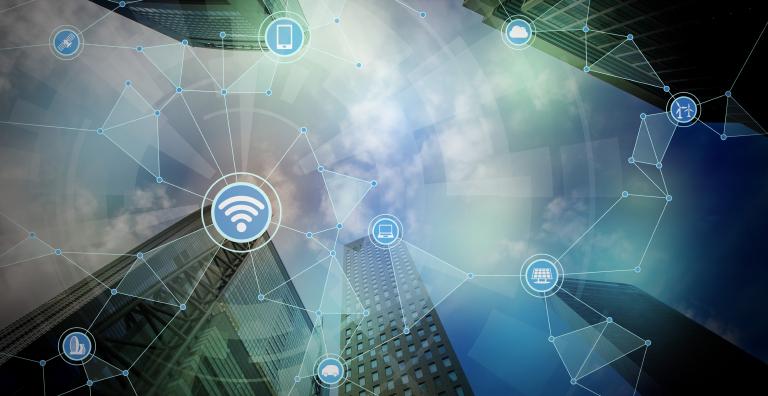 City skyline as seen from below with wifi and other connectivity icons