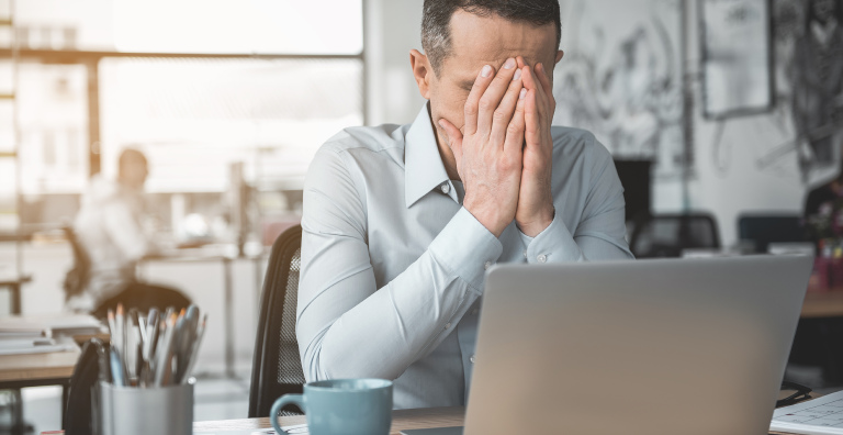 Frustrated man working on a laptop