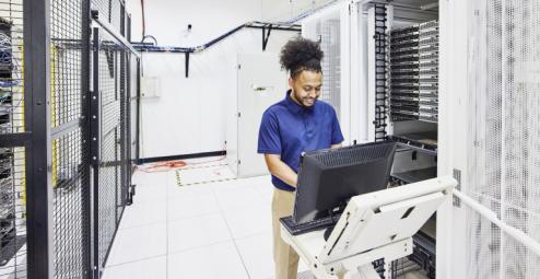 Data center employee uses computer on portable cart