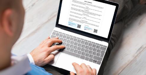 Laptop user reading a legal contract