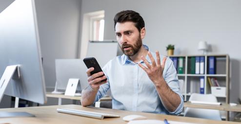 Frustrated man looks at his phone
